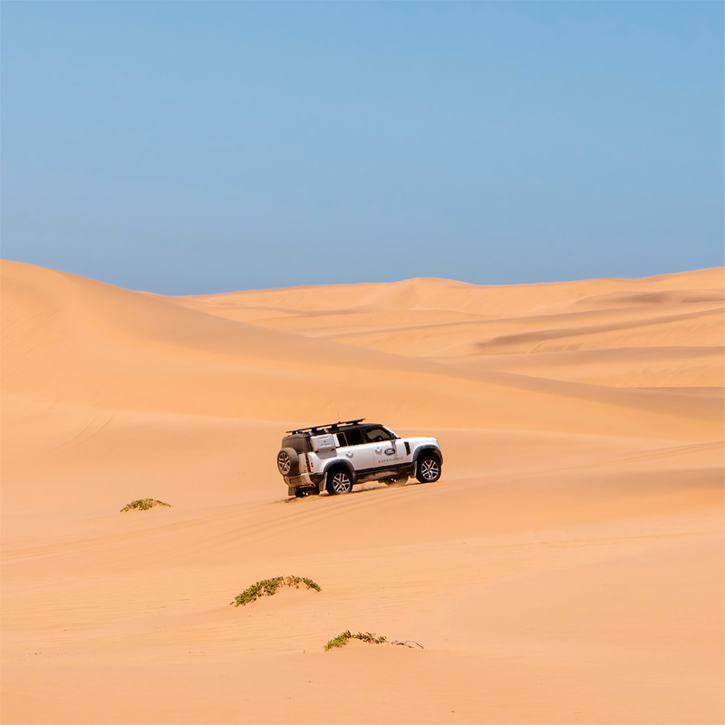 A Land Rover vehicle traversing the sand dunes near Swakopmund, Namibia